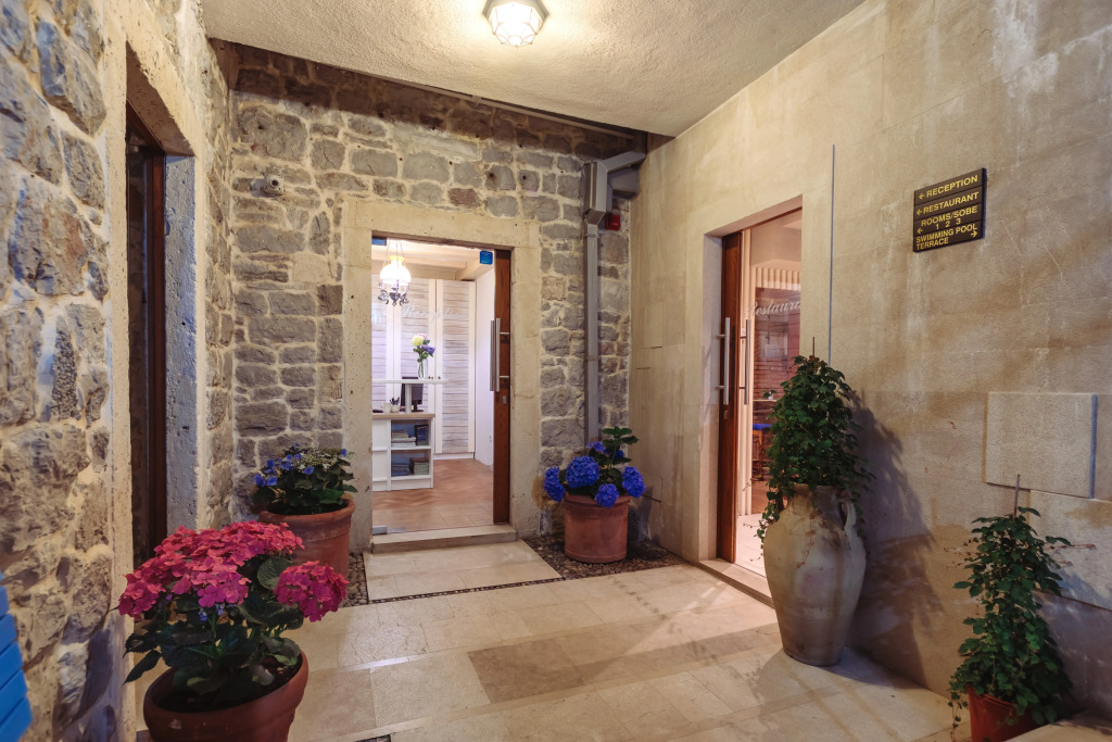 Stone-walled bedroom with canopy bed and open bathroom — Deluxe Double Sea View