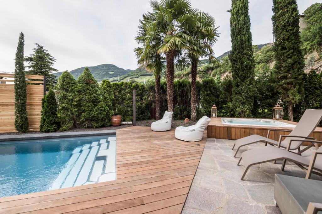 The pool on the wooden deck — palms, cypresses, the South Tyrolean hills behind