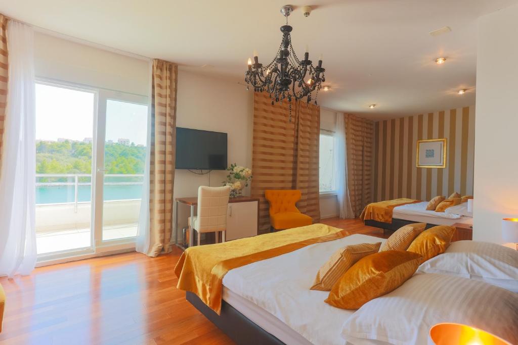 Deluxe Triple — wide balcony door with sea view, chandelier, hardwood floor